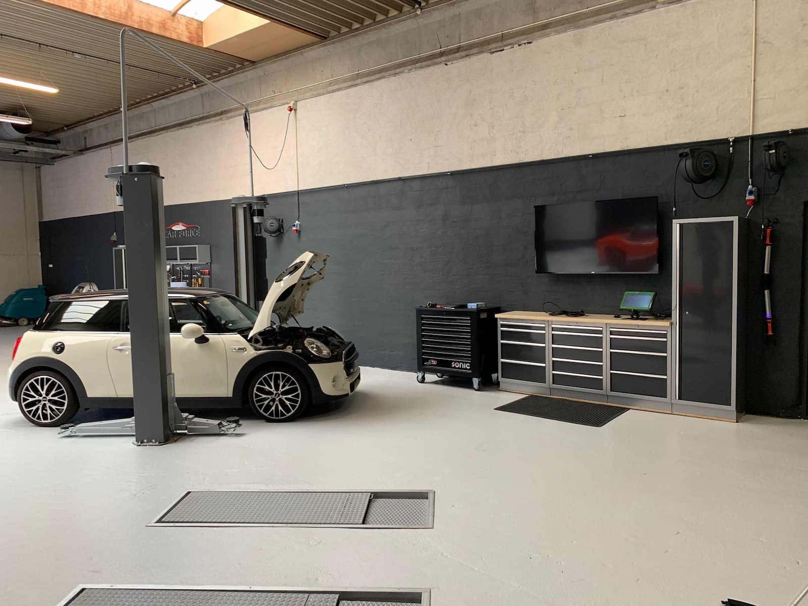 Mini Cooper med åben motorhjelm på lift i Car Force værksted i Hørsholm